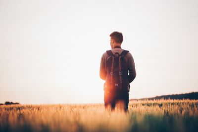 Rear view of man standing on countryside landscape 