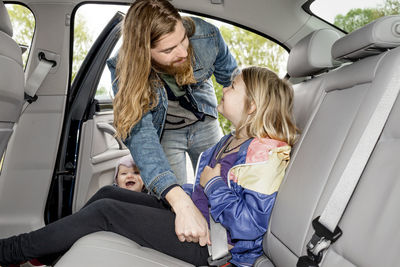 Father checking daughters safety belt