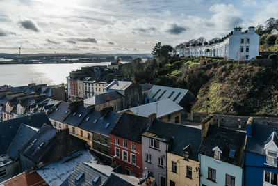 High angle view of houses by sea against sky