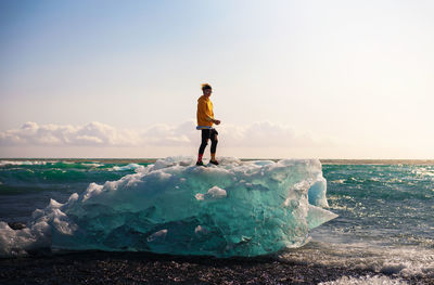 Full length of man standing on sea shore against sky