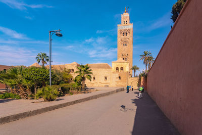 Road amidst buildings against sky