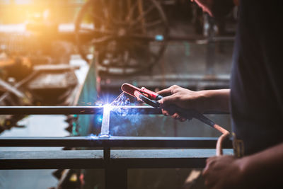 Midsection of welder welding metal in workshop