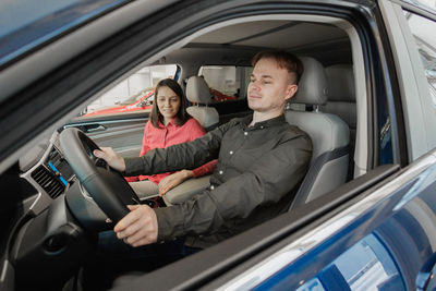 Portrait of young woman sitting in car