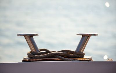 Close-up of metallic hooks against blurred sea