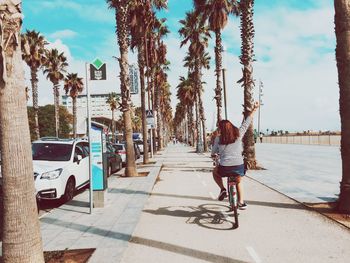 Rear view of woman riding bicycle on street