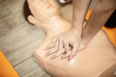 Cropped hands practicing cpr on dummy