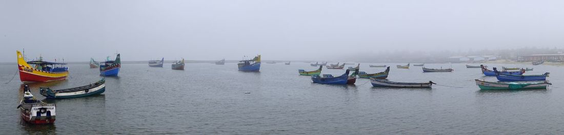 Boats moored on sea against sky