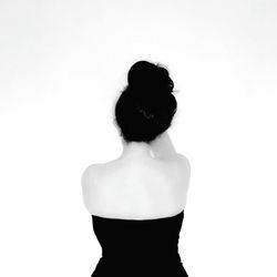 Rear view of woman standing against white background