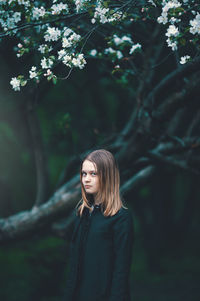 Portrait of girl standing at forest