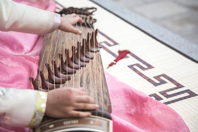 High angle view of woman playing guzheng at home