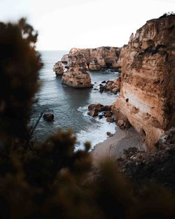 Rock formations in sea against sky