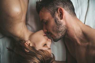 Directly above shot of shirtless couple on bed at home