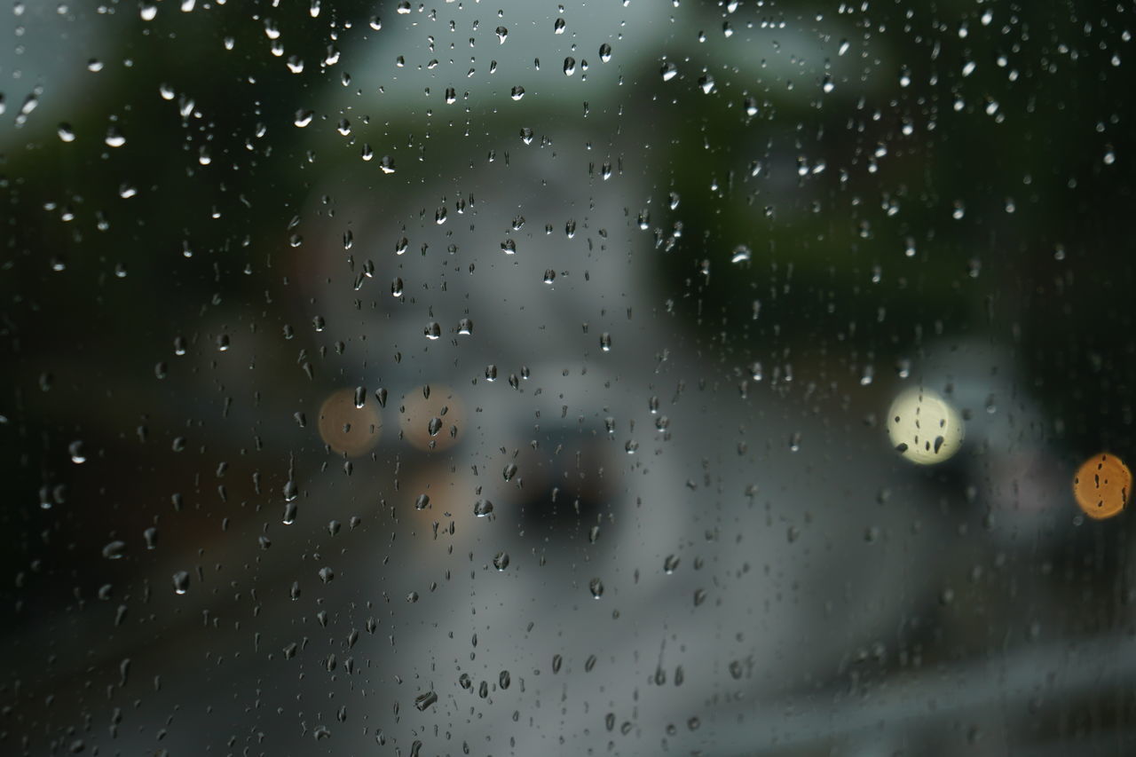 RAINDROPS ON GLASS WINDOW DURING RAINY SEASON