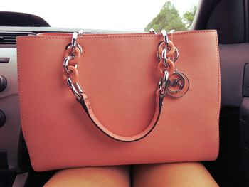 Close-up of a pink handbag on lap