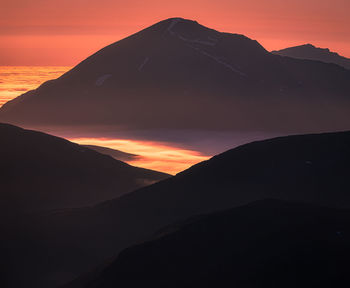 Scenic view of silhouette mountains against sky during sunset