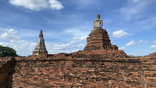 Low angle view of old temple against cloudy sky