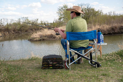 Rear view of man sitting in lake