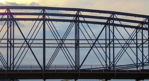 Low angle view of metallic bridge against sky