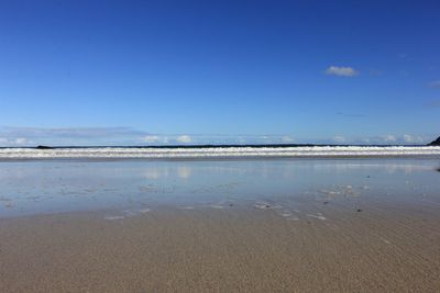 View of calm beach against blue sky