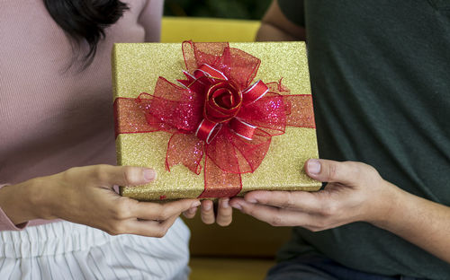 Midsection of couple holding christmas present