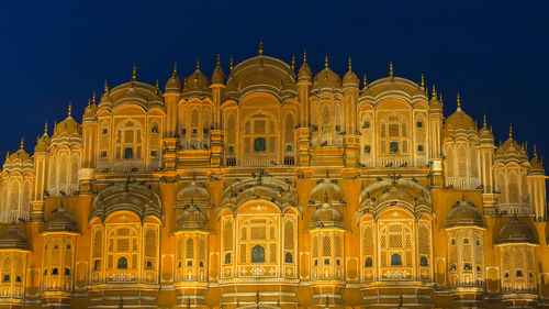 Low angle view of illuminated building against sky at night