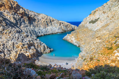 Panoramic view of sea and rocks against blue sky