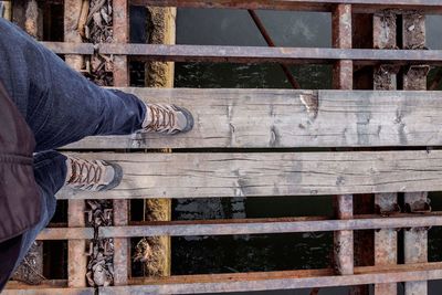 Low section of man standing on railing