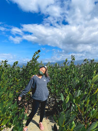 Woman standing on field against sky