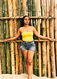 Portrait of woman standing against tree