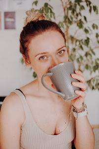 Portrait of young woman drinking coffee