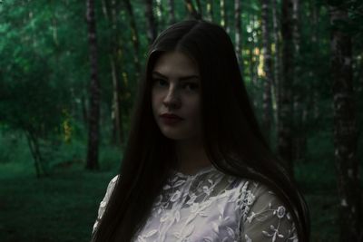 Close-up of young woman standing in forest