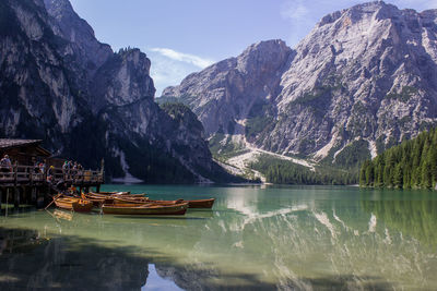 Boats moored on lake against mountains