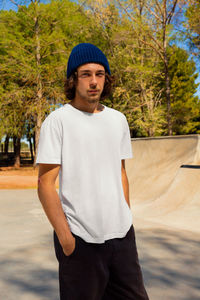 Portrait of young man standing against trees