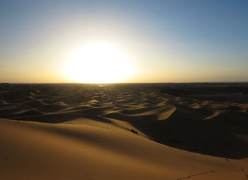 Scenic view of desert against sky during sunset