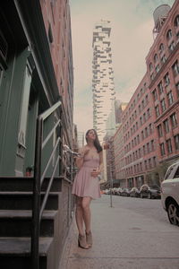 Woman with umbrella on street in city