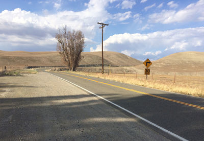 Man standing by road against sky