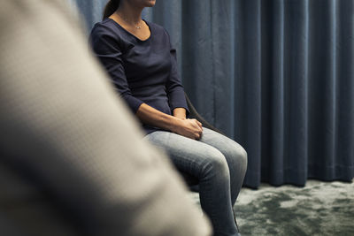 Mid section of woman sitting during meeting