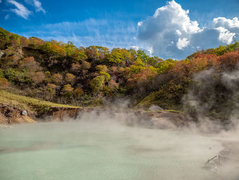 Scenic view of waterfall against sky