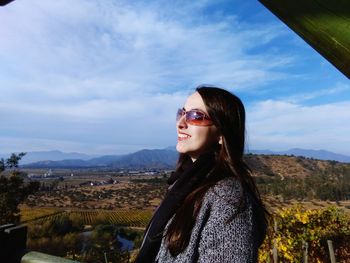 Young woman looking away while standing at observing point against sky