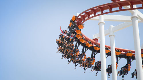 Low angle view of orange decorations hanging against clear sky