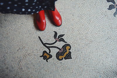 Low section of woman standing on tiled floor