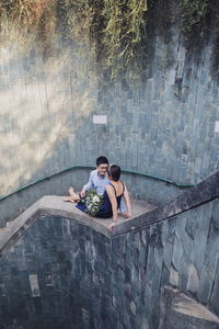 Full length of couple sitting outdoors
