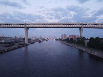 Bridge over river against cloudy sky