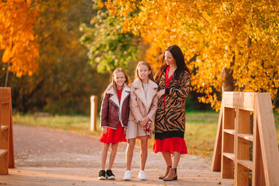 Rear view of women standing on autumn tree