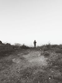 Man standing on field against clear sky