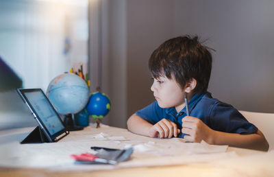 Portrait of boy looking at table at home