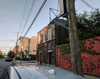 Road by buildings against sky in city