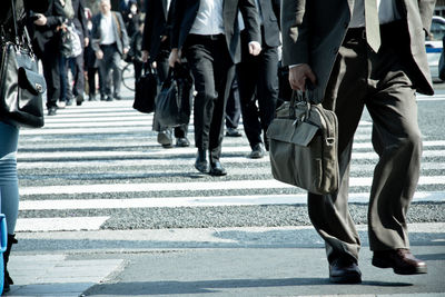 Low section of business people walking on road