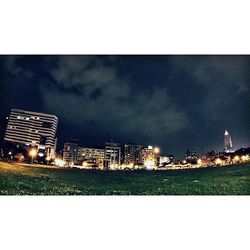 Illuminated city against sky at night