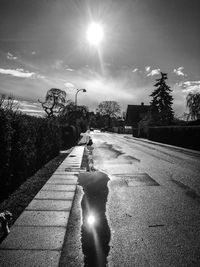 Puddle with reflection of sun on road